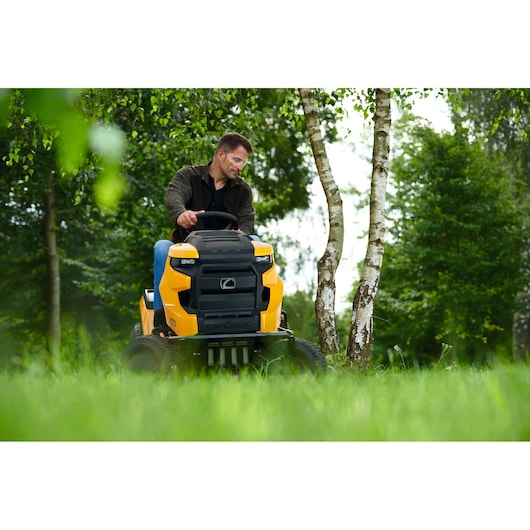 CubCadet 13A8A1TS603 yellow riding mower shown outdoors in grass near birch trees, front view.