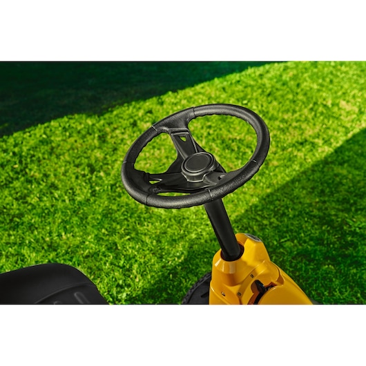 CubCadet 13AB21HD603 lawn tractor steering wheel close-up, yellow body, on green grass.