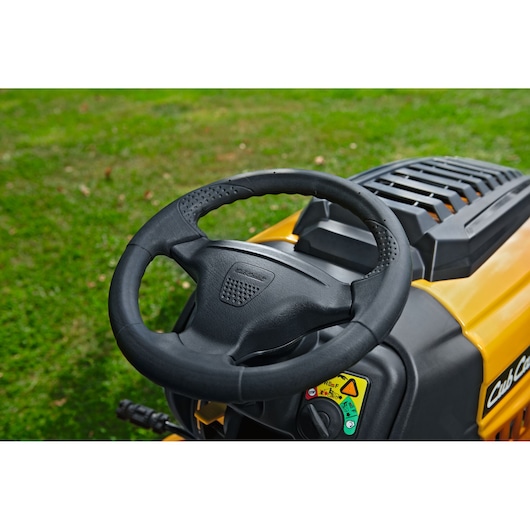 CubCadet LT3-PR105 13AJ71BN603 lawn tractor steering wheel and dashboard, close-up outdoors.