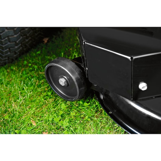 CubCadet LT3-PR105 SKU 13AJ71BN603 mower deck wheel close-up, black, on green grass.