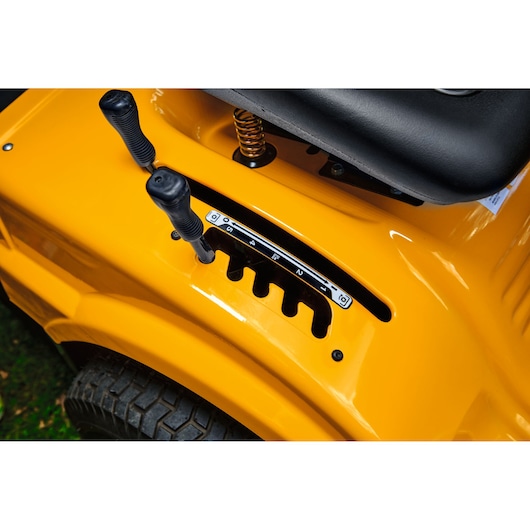 Photo of CubCadet LT3-PR105 SKU 13AJ71BN603 lawn tractor controls, yellow body, seat corner visible, top angle.
