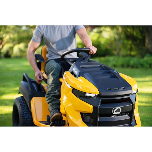 CubCadet 14AFA5TQ603 riding lawn mower close-up, yellow and black, in use in a garden.