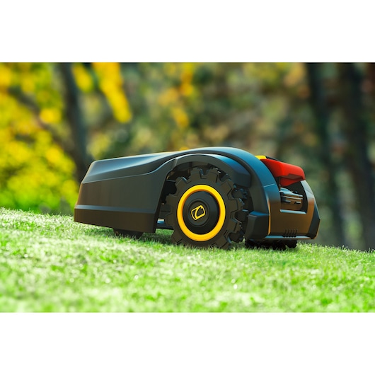 CubCadet 22AKHEFA603 robotic lawn mower with black and yellow wheels on grass, outdoor side view.