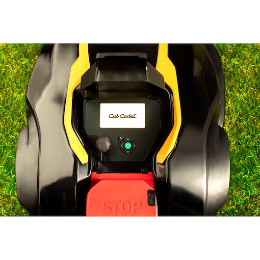 CubCadet 22AKHEFA603 robotic lawn mower control panel, overhead angle, black and yellow housing, red STOP button.