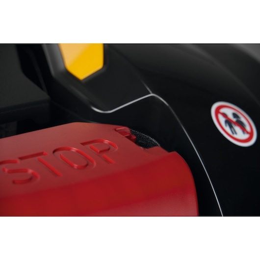 CubCadet 22AKHEFA603 close-up of red STOP button and warning label, black and yellow body, angled view.