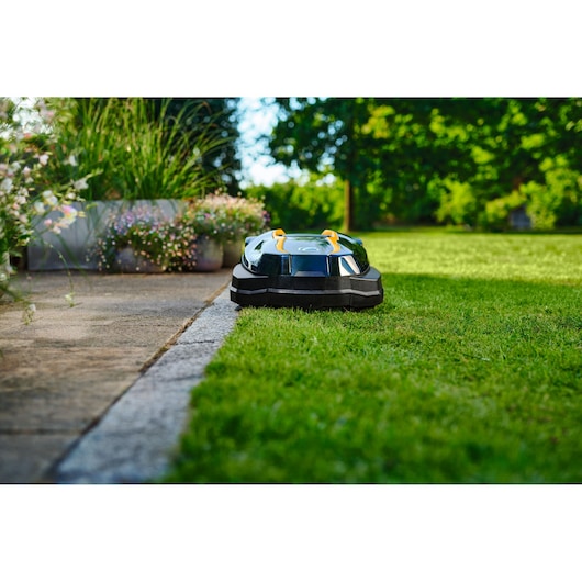 CubCadet 22AKJEFA603 robotic lawn mower on grass in garden, side angle.