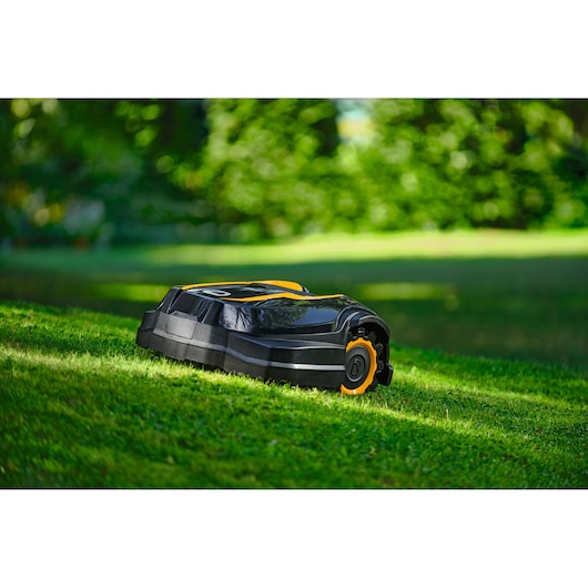 CubCadet 22AKJEFA603 robotic lawn mower, black with yellow accents, shown on grass in outdoor setting.