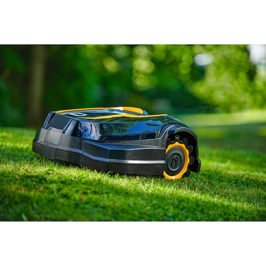 CubCadet 22AKJEFA603 robotic lawn mower on grass, side view, black and yellow body, outdoor setting.