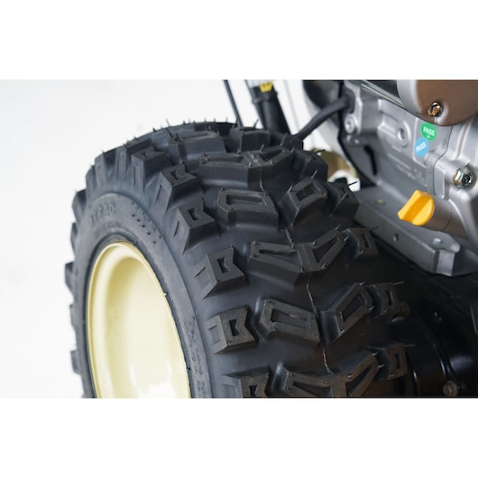 CubCadet 31AY5EVX603 rugged black tire with deep tread, side angle, on light rim, photography product.