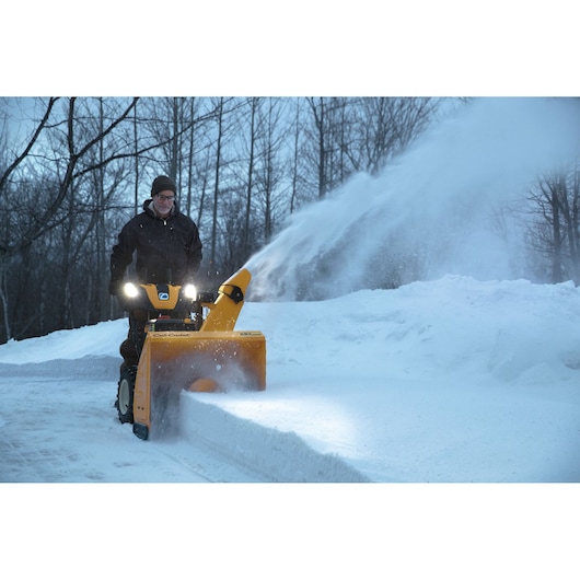 CubCadet 31AY5EVZ603 snow blower in use, clearing snow on a driveway, shown from front angle.