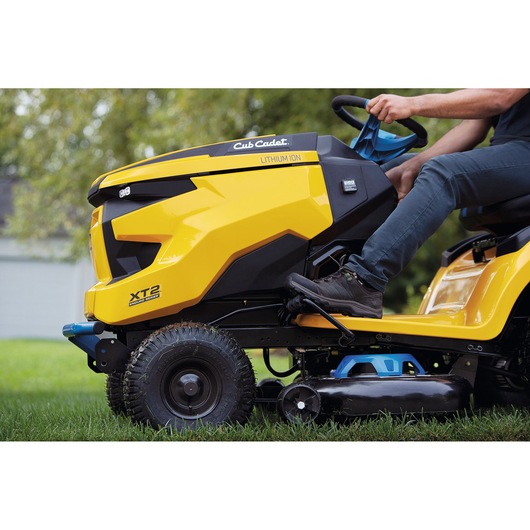 CubCadet 33ABA7ES603 lawn tractor side view, yellow body, XT2 Lithium Ion model in use outdoors.