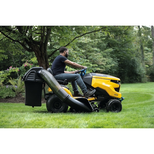 CubCadet 33ABA7ES603 riding lawn mower with rear bagger attachment on grassy lawn, side view.