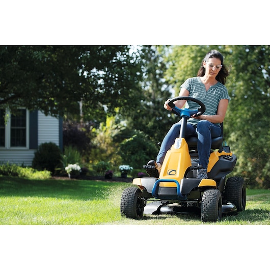 CubCadet 33BA27JD603 lawn mower in use, yellow riding mower cutting grass outdoors.