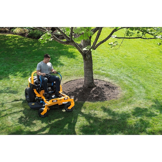 CubCadet 34BBA2CS603 zero-turn lawn mower in use near tree on green yard, wide angle.