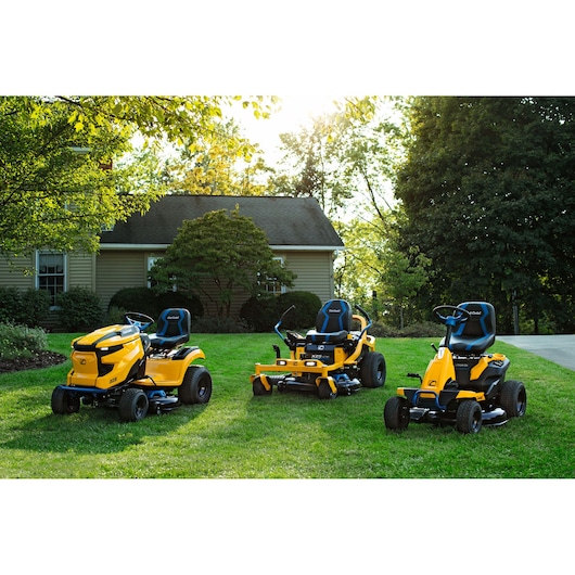 CubCadet 34BBA2CS603 lawn mowers on grass near a house, side angle, showing three yellow models.